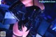 A woman in a black latex outfit posing for the camera.