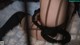 A woman in black stockings and stockings is laying on a white rug.