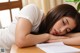 A woman laying on a table with her head on a piece of paper.