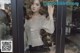 A woman standing in front of a glass door.