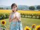 A woman standing in a field of sunflowers.