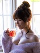 A woman in a pink sweater holding a cup of tea.