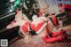 A woman in a santa outfit laying on the floor next to a piano.