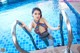 A woman in a bathing suit standing in a swimming pool.